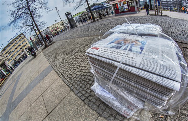 Piles of daily newspapers on the pavement
