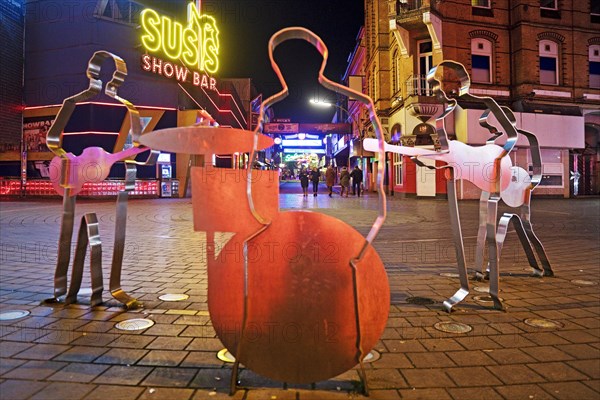 Beatles metal figures on Beatles Square at night