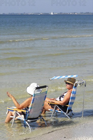 Tourists on sun lounger relaxing in the water