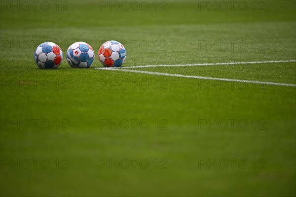 3 match balls adidas Derbystar lie on grass