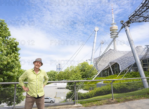 Friendly smiling man at the Olympic tower with Olympic tent roof