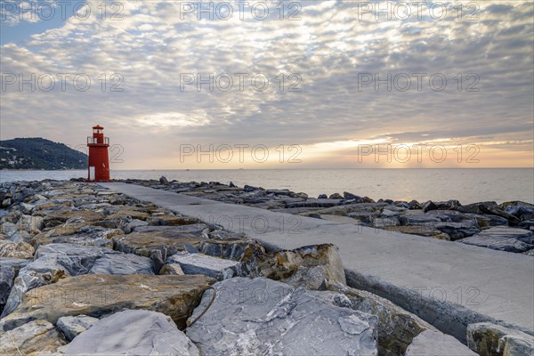 Sunrise with lighthouse at the harbour pier in Porto Maurizio