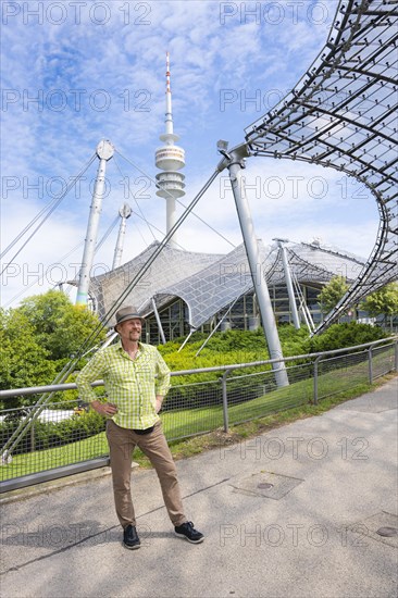 Friendly smiling man at the Olympic tower with Olympic tent roof