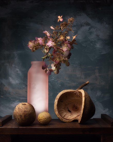 Still life with dried flower in glass bottle