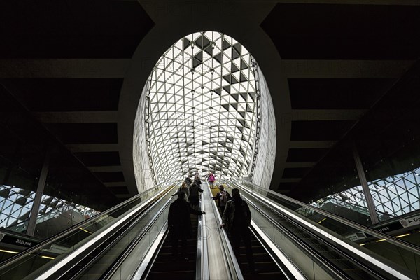 People on escalator with modern skylight