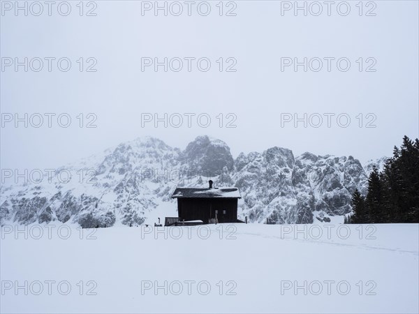 Winter landscape with alpine hut in front of snow-covered Bosruck massif