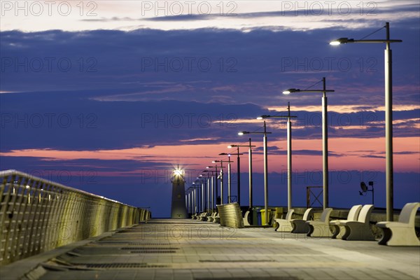 Sunrise with lighthouse at the harbour pier in Porto Maurizio