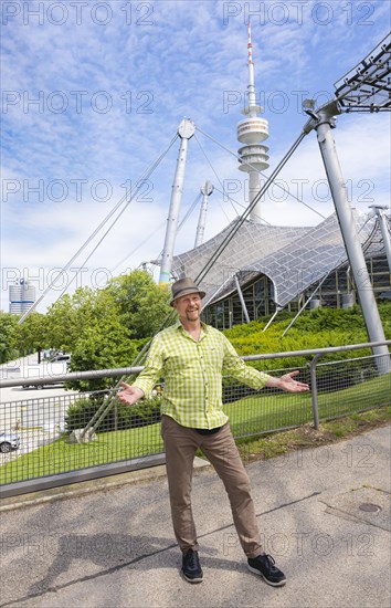 Friendly smiling man at the Olympic tower with Olympic tent roof