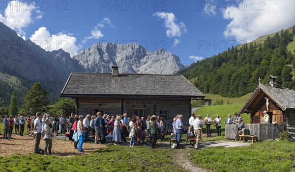 Mass celebration on Almkirtag in front of the wooden chapel in the alpine village of Eng