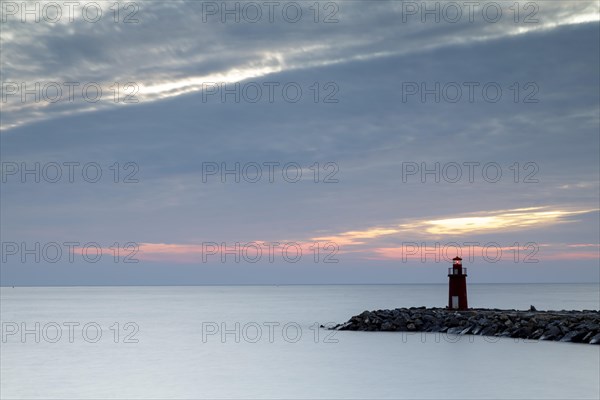 Sunrise with lighthouse at the harbour pier in Porto Maurizio