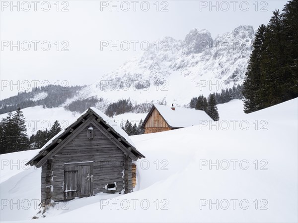 Winter landscape with alpine huts in front of snow-covered Bosruck massif
