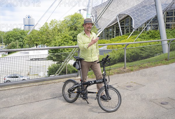 Man with bicycle on the Olympic tent roof