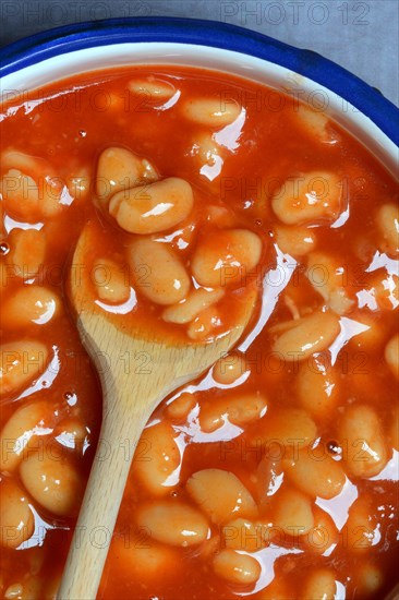White beans with tomato sauce and cooking spoon
