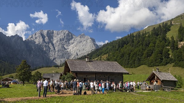 Mass celebration on Almkirtag in front of the wooden chapel in the alpine village of Eng