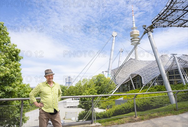 Friendly smiling man at the Olympic tower with Olympic tent roof