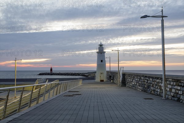 Sunrise with lighthouse at the harbour pier in Porto Maurizio