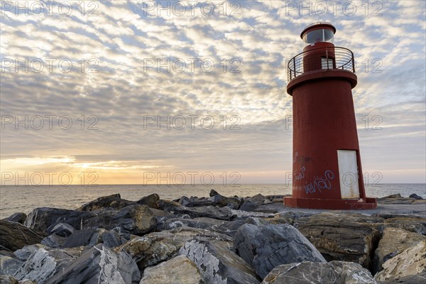 Sunrise with lighthouse at the harbour pier in Porto Maurizio