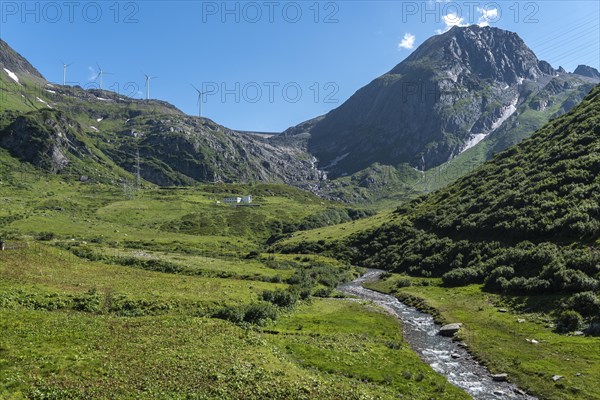Alpine landscape along the Nufenen Pass road with wind turbine below Lake Gri