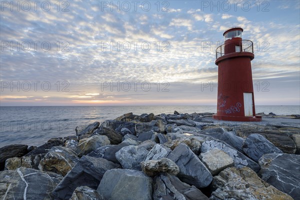 Sunrise with lighthouse at the harbour pier in Porto Maurizio