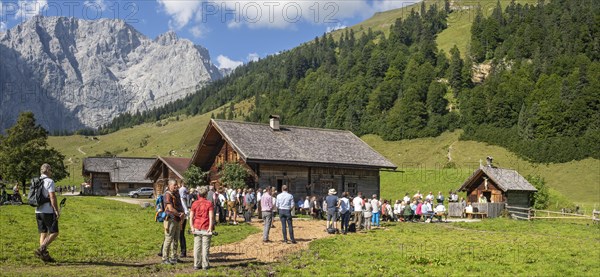 Mass celebration on Almkirtag in front of the wooden chapel in the alpine village of Eng