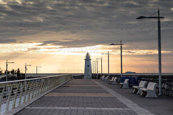 Sunrise with lighthouse at the harbour pier in Porto Maurizio