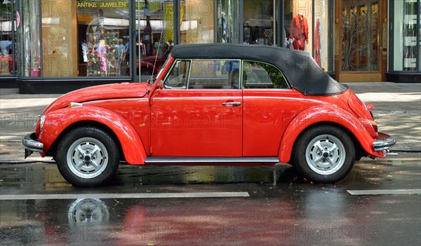 A red VW Beetle convertible stands on the rain-soaked Kurfuerstendamm in Berlin