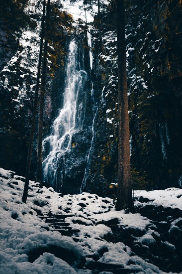 The Burgbach waterfall in winter with snow and ice