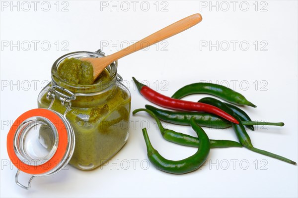 Green Thai curry paste in jar and chillies