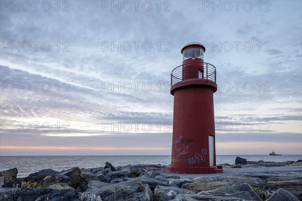 Sunrise with lighthouse at the harbour pier in Porto Maurizio