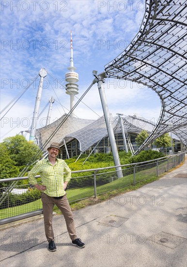 Friendly smiling man at the Olympic tower with Olympic tent roof