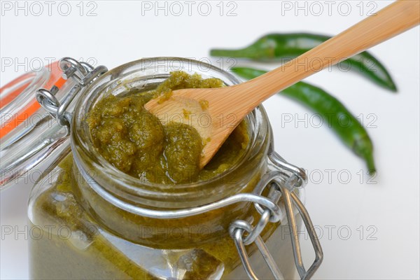 Green Thai curry paste in jar and chillies