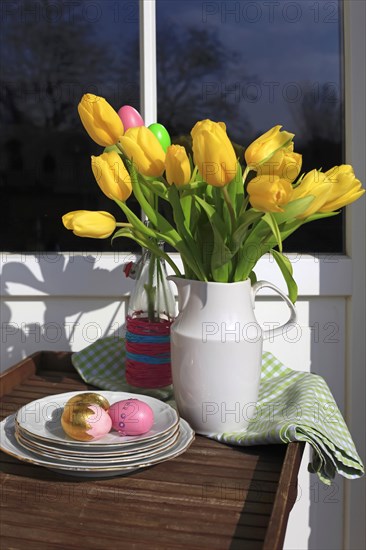 Bouquet of tulips and Easter eggs on a balcony