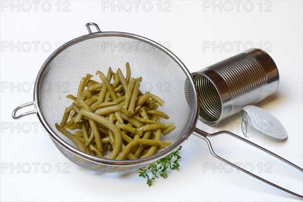 Green beans and savory in sieve and tin