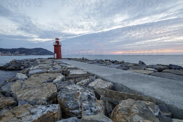 Sunrise with lighthouse at the harbour pier in Porto Maurizio