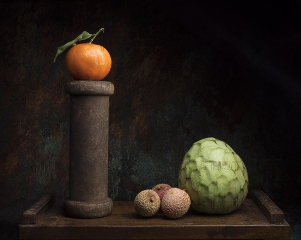 Still life with mandarin on wooden spool