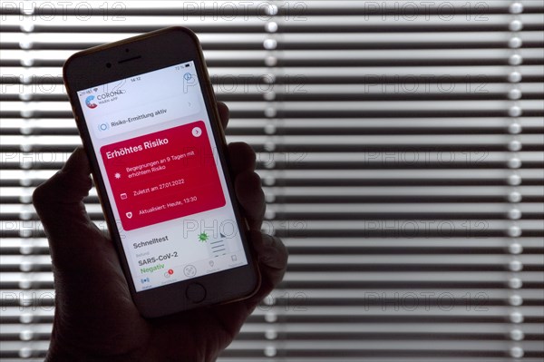 Hand holding smartphone with Corona warning APP