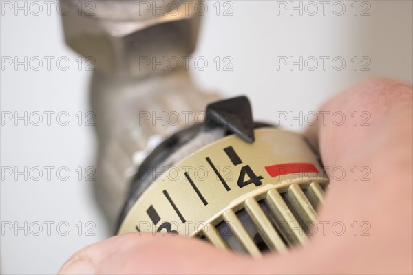 Hand on the heating thermostat