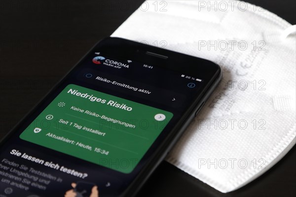 FFP2 mask and iPhone with low-risk Corona warning app