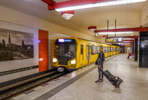 Woman with suitcase waiting for arriving underground