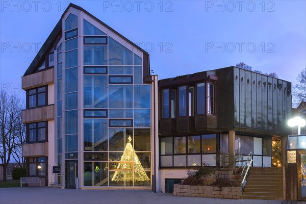 Town hall in the evening light with reflection of an illuminated Christmas fountain