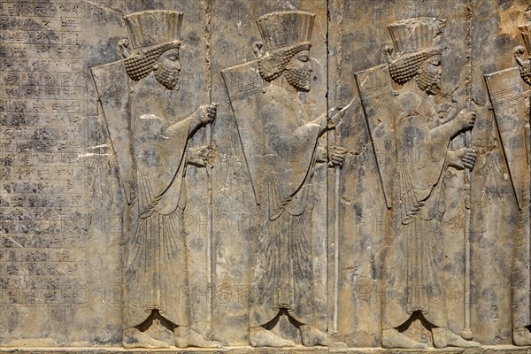 Persian guards at the west staircase of Darius Palace with cuneiform writing