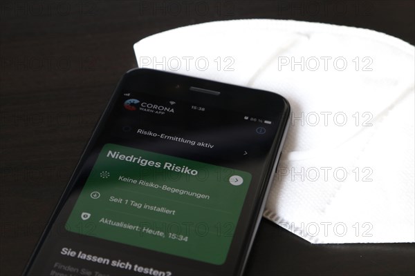 FFP2 mask and iPhone with low-risk Corona warning app