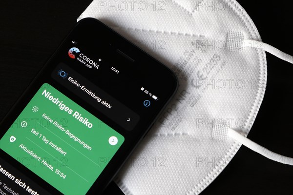 FFP2 mask and iPhone with low-risk Corona warning app