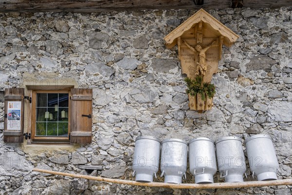 Milk cans lined up on a wooden bench