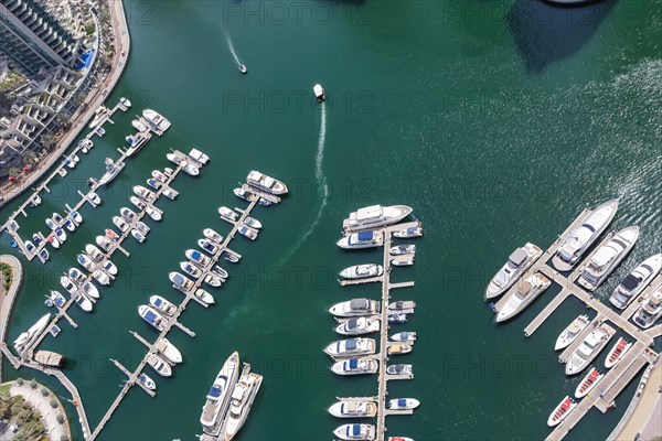 Dubai Marina and Harbour luxury wealth holiday with boats yacht from above in Dubai