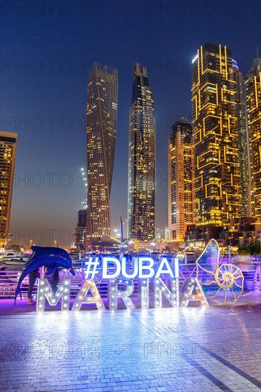 Dubai Marina Logo and Harbour Skyline Architecture Luxury Holiday in Arabia with Boat Yacht by Night in Dubai