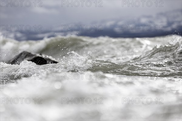 Storm Lolita raging on the rocky shore with waves in Hagnau