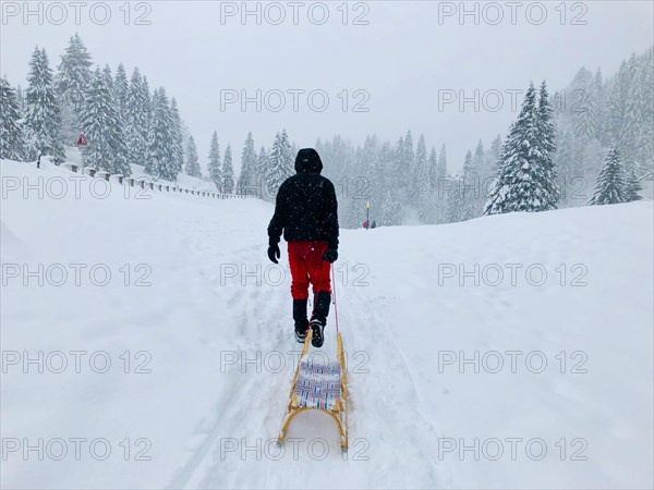 Man pulling a sledge through the snow