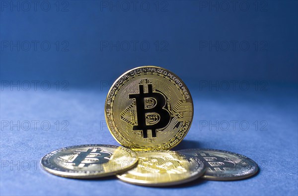 Bitcoin BTC crypto currency gold coins on blue background