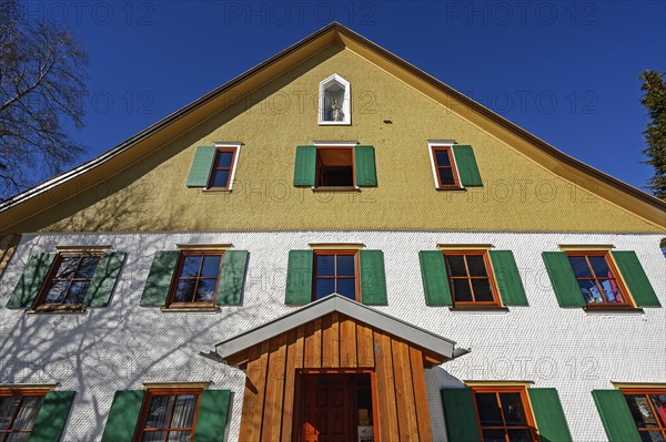 Facade with wooden shingles and figure of the Virgin Mary